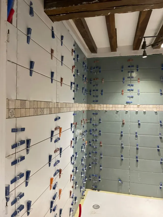 Pose de carrelage mural en cours — réalisation Fornillo